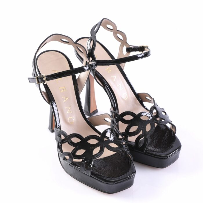 Black patent-leather high-heeled sandals with a decorative cutout floral pattern and ankle strap