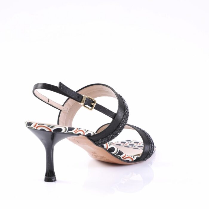 Black strappy mid-heel sandal with a buckle ankle strap and patterned sole, shown from a rear-side angle