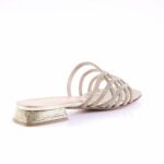 Silver strappy sandal with rhinestone-studded straps and a low textured heel in metallic finish.
