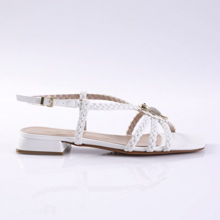White braided-strap sandal with ankle strap and rhinestone embellishment, low block heel visible from the side.