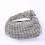 Silver rhinestone clutch bag with a twisted strap and rounded shape.