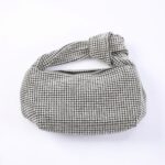 Silver rhinestone-covered clutch bag with a knotted strap feature at the top.