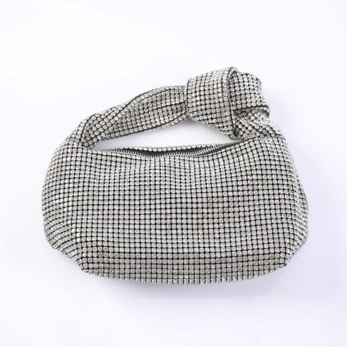Silver rhinestone-covered clutch bag with a knotted strap feature at the top.