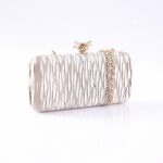Metallic pink crinkled clutch with a gold chain, photographed on a white surface.