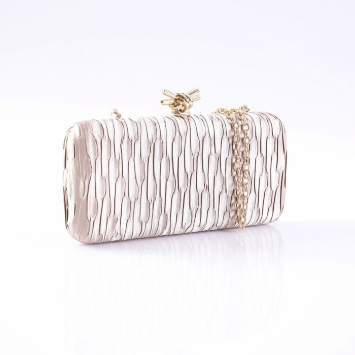 Metallic pink crinkled clutch with a gold chain, photographed on a white surface.