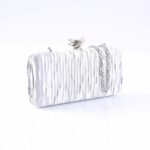 Silver textured clutch purse with a short chain strap on a white reflective surface