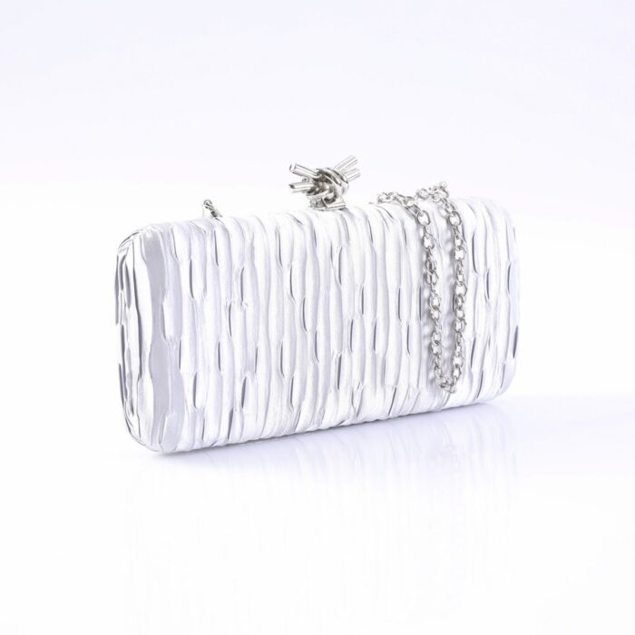 Silver textured clutch purse with a short chain strap on a white reflective surface