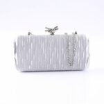 Silver textured clutch with a knot clasp and silver chain strap
