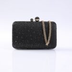 Black beaded evening clutch with a gold chain strap and rounded top clasp on a light background, front view.