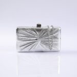 Silver rectangular evening clutch with a radial pleated design and a silver chain strap on a reflective surface