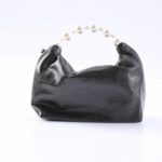 Black satin handbag with a pearl beaded handle, set against a white background.