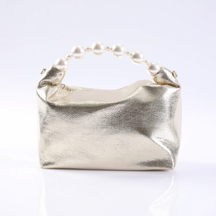 Gold metallic clutch purse with a pearl bead handle resting on a white surface.