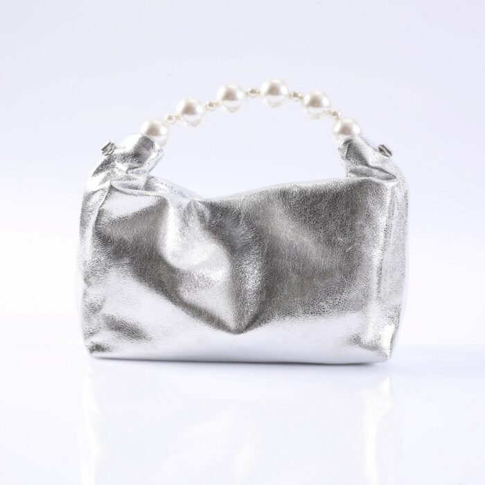 Silver metallic clutch with a pearl bead handle, resting on a white reflective surface.