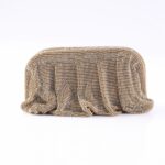 Gold beaded clutch bag with a shimmering, textured surface on a white background.
