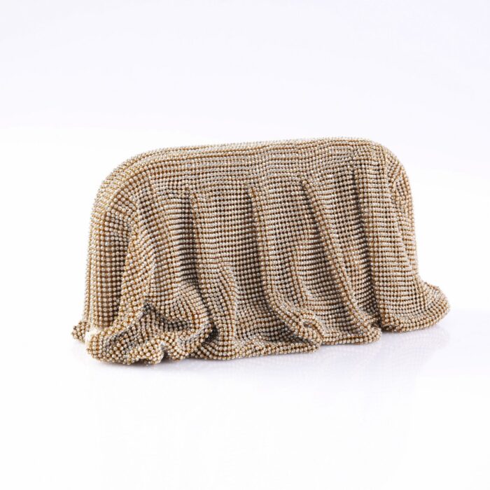 Gold-toned beaded clutch bag draped over a white surface, sparkling with tiny beads.
