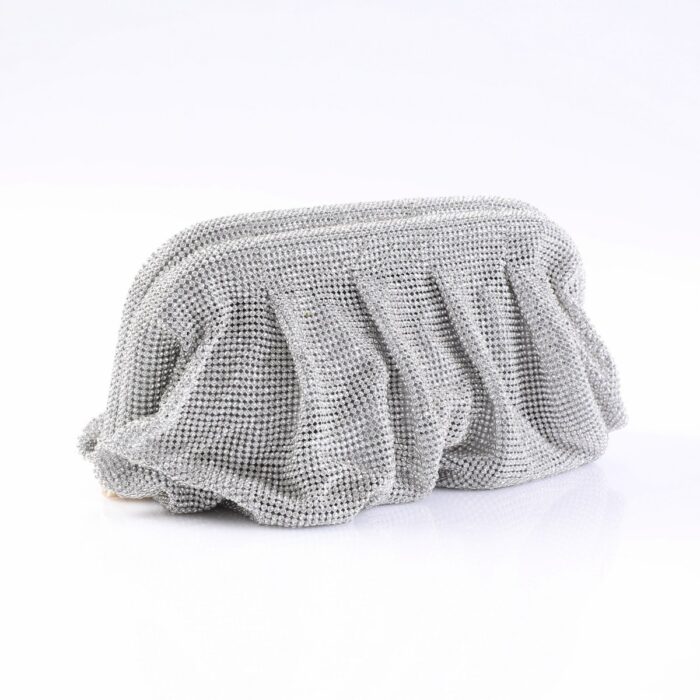 Shimmering silver bead-embellished clutch bag resting on a white surface in a studio setting.