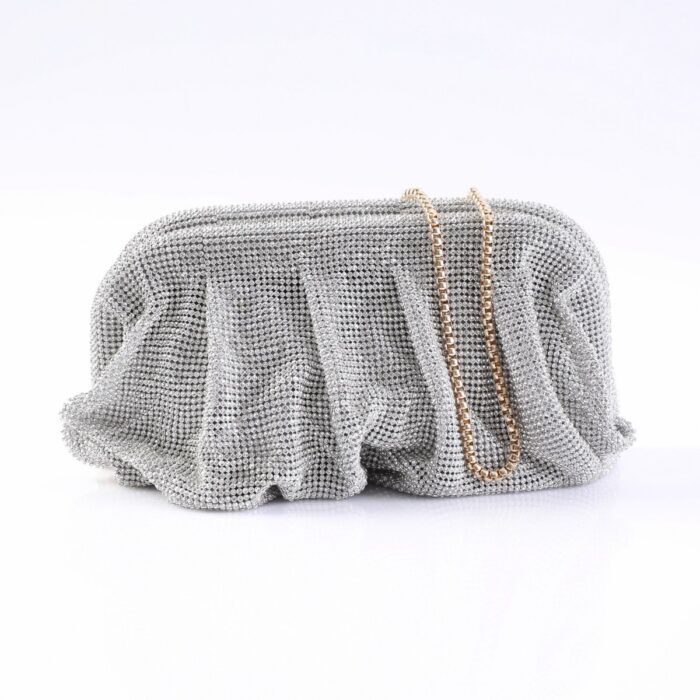 Silver beaded clutch purse with a gold chain strap resting on a white surface.