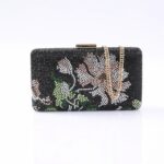 Beaded black clutch with floral pattern and a gold chain strap, set against a white background.