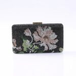 Beaded black clutch with pink and white floral pattern and a gold clasp.