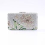 Silver beaded clutch bag with a subtle pink and green floral design and a metal clasp.