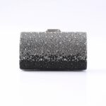 Beaded gradient evening clutch bag from silver to black, resting on a white surface.