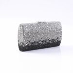 Clutch purse encrusted with silver and black rhinestones on a white surface.