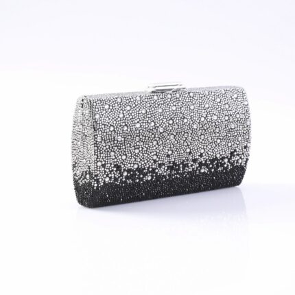 Clutch purse encrusted with silver and black rhinestones on a white surface.