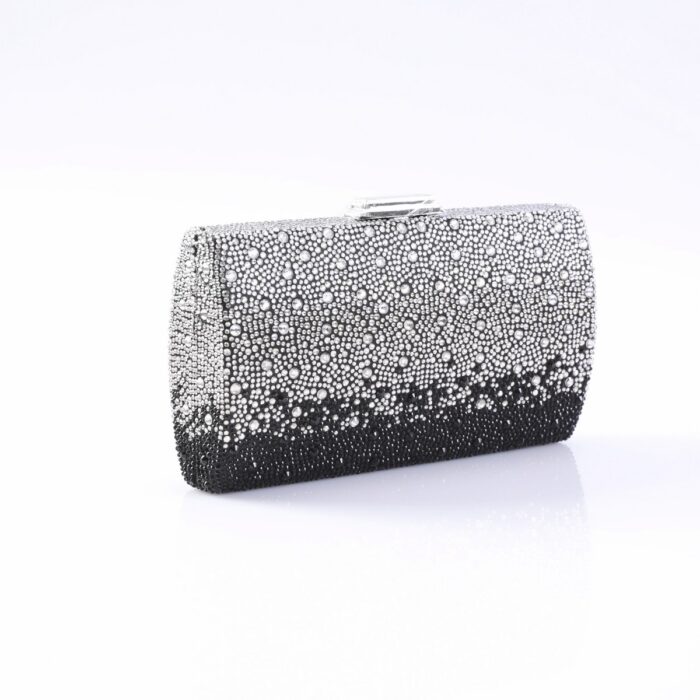 Clutch purse encrusted with silver and black rhinestones on a white surface.