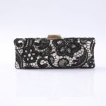 Black lace evening clutch with a gold-tone clasp on a white background, showcasing intricate floral pattern.