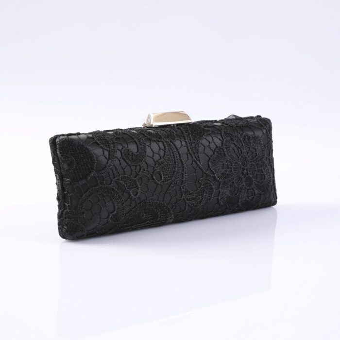 Black lace-clad evening clutch with a metallic clasp, resting on a white reflective surface