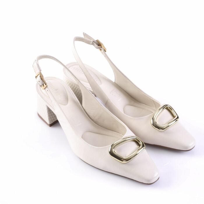 Cream slingback heels with a gold square buckle at the toe and a textured block heel against a white background.