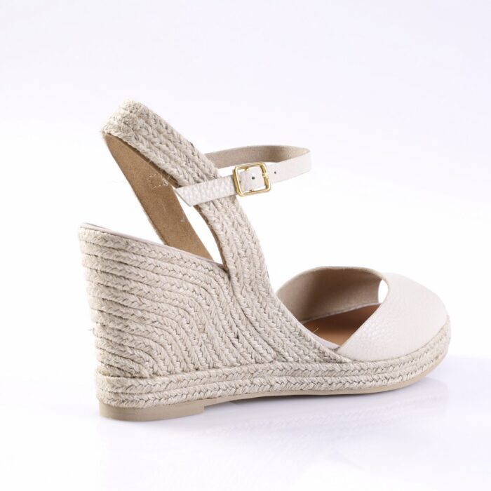 Cream-colored espadrille wedge sandal with braided rope heel and ankle strap with a gold buckle