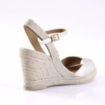 Beige espadrille wedge sandal with braided jute heel and ankle strap with gold buckle.