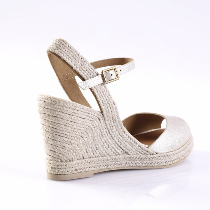 Beige espadrille wedge sandal with braided jute heel and ankle strap with gold buckle.