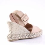 Beige espadrille wedge sandal with braided rope sole and wide ankle strap with square buckle.
