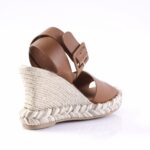 Brown leather wedge sandal with a braided rope espadrille sole and buckle strap on a white background