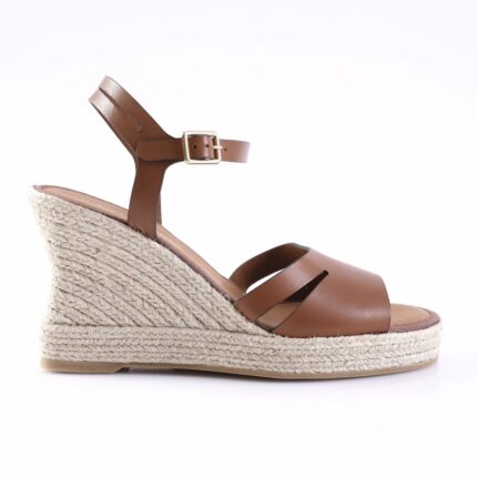 Brown leather wedge sandal with ankle strap and buckle on a braided jute platform, side view.