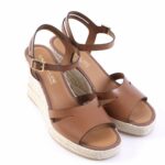 Brown leather wedge sandals with ankle straps and braided jute platform.
