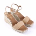 Beige wedge espadrille sandals with ankle straps and open toes, on a white background
