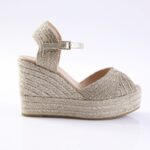 Beige metallic woven espadrille wedge sandal with ankle strap and buckle.