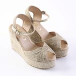 Gold braided wedge espadrille sandals with ankle strap and peep toe on a white background