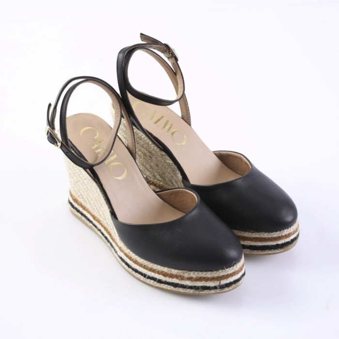 Black leather wedge espadrille sandals with ankle straps and braided rope sole for women.