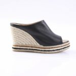 Black leather open-toe wedge sandal with a braided jute platform and striped sole edge