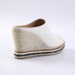 White leather espadrille wedge sandal with a braided jute heel and a striped sole edge along the bottom.