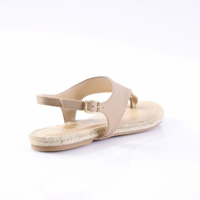 Beige open-toe sandal with an ankle strap and gold buckle on a woven espadrille-style sole.