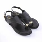 Black leather sandals with an ankle strap and gold dome accents at the toe post, shown on a white background.