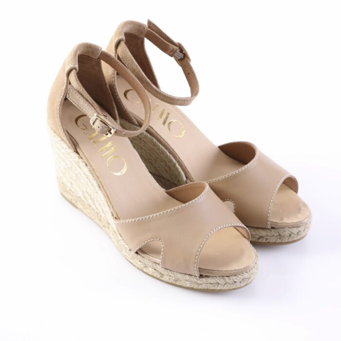 Beige peep-toe wedge espadrille sandals with ankle strap and buckle on a white background.