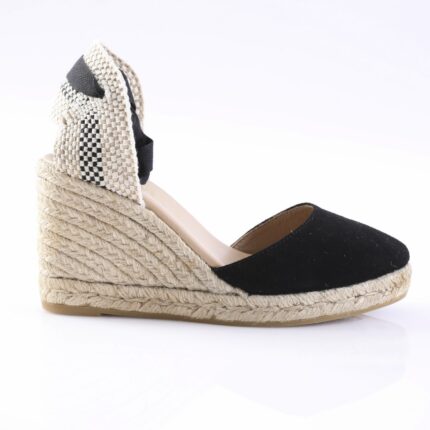 Black espadrille wedge sandal with a woven rope sole, black toe, and a checkered fabric back strap with ankle tie