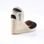 Espadrille wedge sandal with braided jute sole and black fabric straps, viewed from the back.