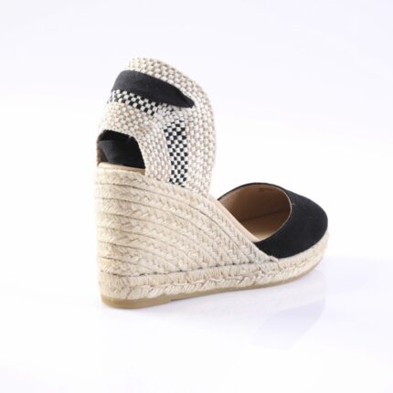 Espadrille wedge sandal with braided jute sole and black fabric straps, viewed from the back.